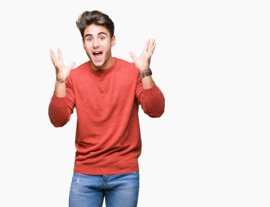 Yakışıklı delikanlı deli kutluyor ve silah ile başarı için heyecanlı çığlık kaldırdı ve açık gözleri hayret izole arka plan üzerinde. Kazanan kavramı