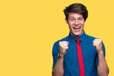 İzole arka plan kutlama üzerinde giyen kırmızı kravat şaşırttı ve silah ile başarı için hayran genç yakışıklı iş adamı kaldırdı ve gözleri açık. Kazanan kavramı.