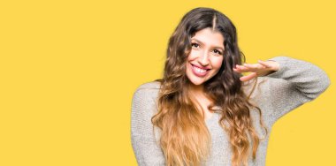 Kış ile büyük ve büyük boy işaret, ölçü birimi sembol gösteren el elbise eller giyen genç güzel kadın. Kameraya bakarak gülümsüyordu. Ölçüm kavramı.