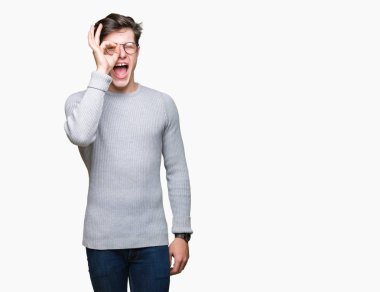 Gülümseyen, parmakları ile mutlu yüz üzerinden seyir göz el ile ok jest yapıyor izole arka plan üzerinde gözlük takan genç yakışıklı adam.