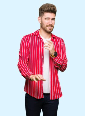 Kırmızı gömlek giymiş genç yakışıklı adam tiksinti ifadesi, memnun ve korkulu tiksinti yüz yapıyorsun çünkü nefret tepki. Elleriyle kaldırdı. Sinir bozucu kavramı.