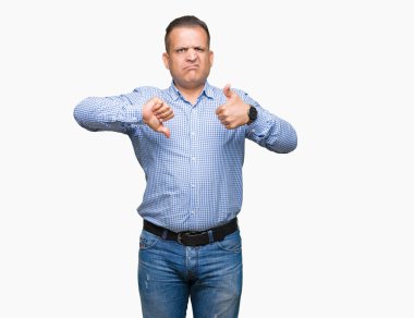 Orta yaş Arap iş adamı izole arka plan yapmaya başparmak yukarı ve aşağı, anlaşmazlık ve anlaşma ifade üzerinde. Deli çatışma