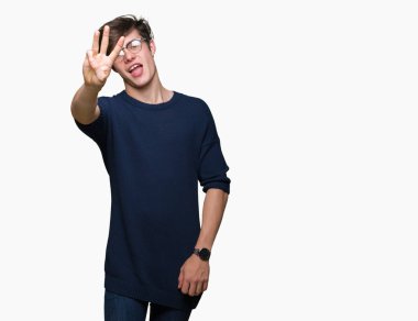 Gösterilen arka plan üzerinde gözlük takan genç yakışıklı adam izole ve parmakları ile işaret üçüncü gülümseyen ise kendinden emin ve mutlu.