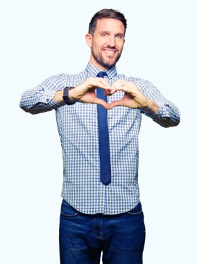 Yakışıklı iş adamı aşık kalp simgesi ve elleriyle şekil gösteren gülümseyen kravat takıyor. Romantik kavramı.