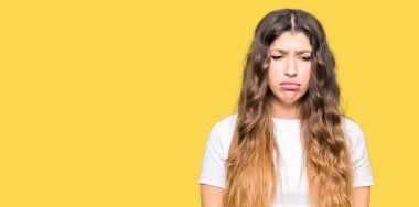 Casual beyaz t-shirt giyen genç güzel kadın depresif ve kızgın ve korkmuş ağlıyor sıkıntı için endişeleniyorum. Üzgün ifade.