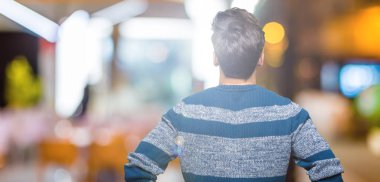 Geriye doğru uzakta silah ile vücut üzerinde seyir izole arka plan ayakta genç yakışıklı adam