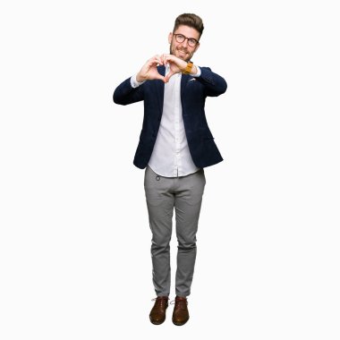 Kalp simgesi ve elleriyle şekil gösterilen aşık gülümseyen gözlüklü genç yakışıklı iş adamı. Romantik kavramı.