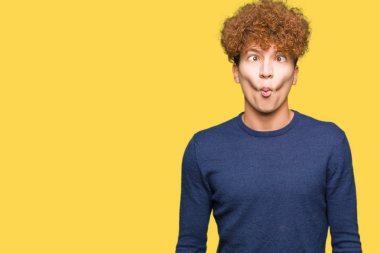 Dudakları, çılgın ve komik jest ile balık yüz yapma afro saçlı genç yakışıklı adam. Komik ifade.