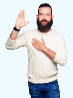 Kış kazak giyen genç hipster adam göğüs ve bir sadakat sözü yemin yapma avuç, el ile küfür