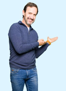 Orta Çağ yakışıklı adam bir kazak giyiyor açık el ile gülümseyen doğal girmek için davet