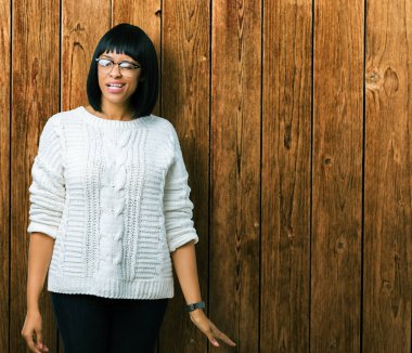 Güzel genç Afro-Amerikan kadın seksi bir ifadeyle, neşeli ve mutlu yüzünü kameraya bakarak göz kırpıyor izole arka plan üzerinde gözlük.