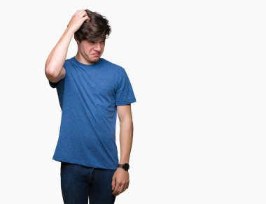 Yakışıklı delikanlı izole arka plan üzerinde mavi t-shirt giyen yanıltır ve soru hakkında merak ediyorum. Şüphe, kafasına el ile düşünme ile belirsiz. Dalgın kavramı.