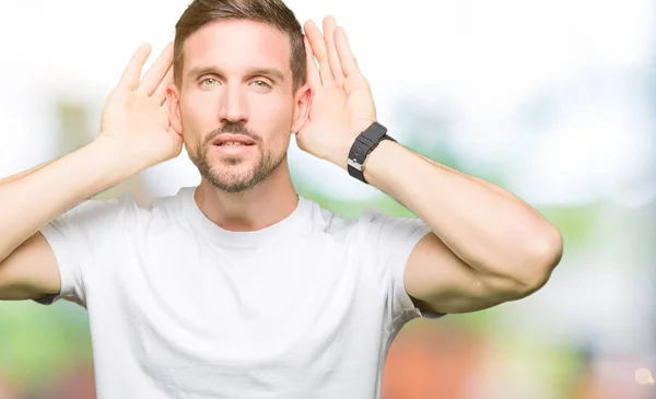 Pohledný Muž Neformálním Bílém Tričku Pokoušíš Slyšet Obě Ruce Ušním — Stock fotografie