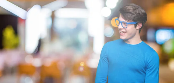 Joven Hombre Guapo Con Gafas Azules Sobre Fondo Aislado Mirando —  Fotos de Stock