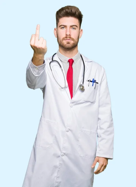 Νεαρός Γιατρός Όμορφος Άνθρωπος Φορώντας Ιατρική Παλτό Δείχνει Μεσαίο Δάχτυλο — Φωτογραφία Αρχείου