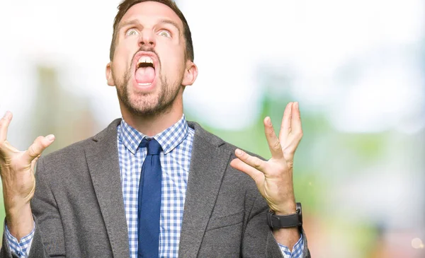 Yakışıklı iş adamı giyen takım elbise ve kravat deli ve deli çığlık ve saldırgan ifade ve silah ile bağırdı kaldırdı. Hayal kırıklığı kavramı.