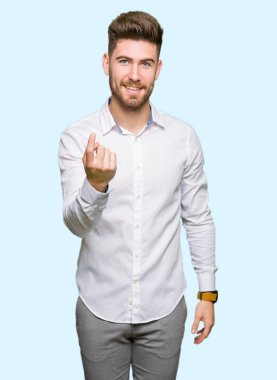 Genç yakışıklı iş adamı Beckoning gel burada mutlu ve gülümseyerek el davet ile jest