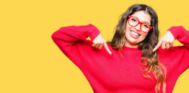 Yüzünde gülümseme ile kendinden emin görünüyorsun, kendini gururlu ve mutlu parmakları ile işaret kırmızı gözlük takan genç güzel kadın.