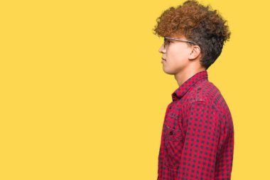 Tarafına, seyir güneş gözlüğü takıyor afro saçlı Genç yakışıklı adam sakin ol kendine güvenen gülümseme ile doğal yüz pozuyla profili.