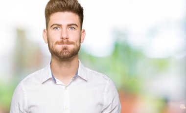 Genç yakışıklı iş adamı komik surat ile yanakları şişirme. Ağız ile hava, deli ifade şişirilmiş.