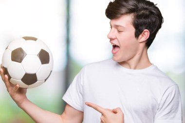 Genç adam futbol futbol topu izole arka plan üzerinde çok mutlu el ve parmak ile işaret tutan
