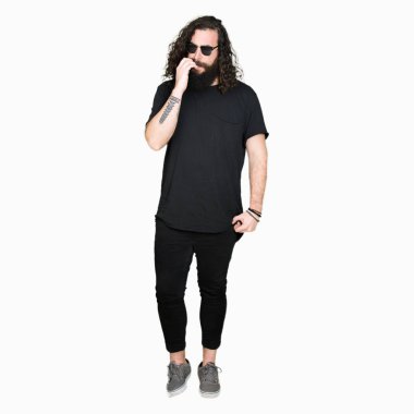 Uzun saç ve sakal stresli ve gergin ile güneş gözlüğü takmış genç hipster adamla tırnak ısırma dudaklarından eller. Anksiyete sorunu.