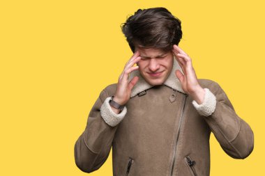 Genç yakışıklı adam giyen kış ceket baş baş ağrısı için el ile izole arka plan üzerinde çünkü stres. Migren muzdarip.