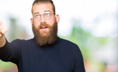 İfade, bir şey önde genç sarışın adam giyen gözlük ve balıkçı yaka kazak ile sürpriz devam parmakla, açık ağız hayran