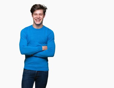 Üzerinde mavi kazak giyen genç yakışıklı adam mutlu yüz ile gülümseyerek kameraya seyir silah geçti arka plan izole. Olumlu bir kişi.