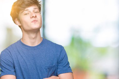 Görünümlü yan ve dik dik bakma uzağa düşünce gülümseyen izole arka plan üzerinde mavi t-shirt giyen genç yakışıklı adam.