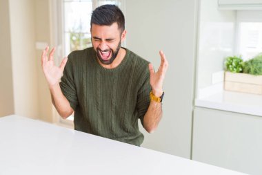 Yakışıklı İspanyol adam evde rahat kazak giyen silah kaldırdı ve kapalı gözleri heyecan çığlık ile başarı için deli ve deli kutluyor. Kazanan kavramı