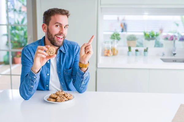 Όμορφος Άνθρωπος Τρώει Μπισκότα Τσιπ Σοκολάτας Πολύ Χαρούμενη Δείχνοντας Χέρι — Φωτογραφία Αρχείου