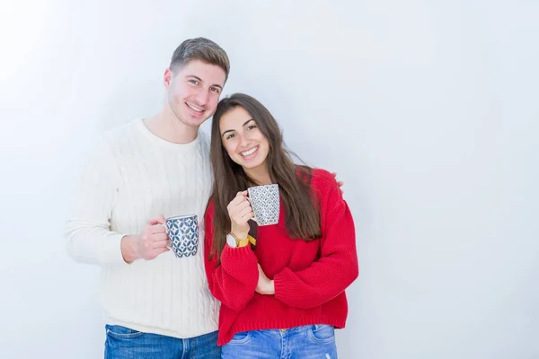 美丽的年轻夫妇在白色孤立的背景喝一杯咖啡与幸福的脸站和微笑与自信的微笑显示牙齿 — 图库照片