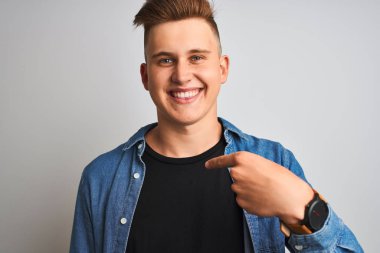 Kendine işaret sürpriz yüzü ile izole beyaz arka plan üzerinde duran denim gömlek giyen genç yakışıklı adam