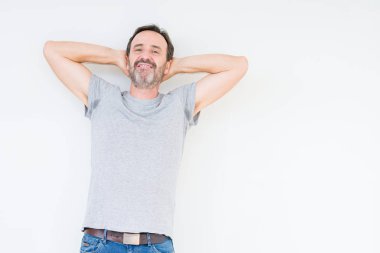 Izole arka plan üzerinde Yakışıklı yaşlı adam rahatlatıcı ve kollar ve eller baş ve boyun arkasında germe, mutlu gülümseyen