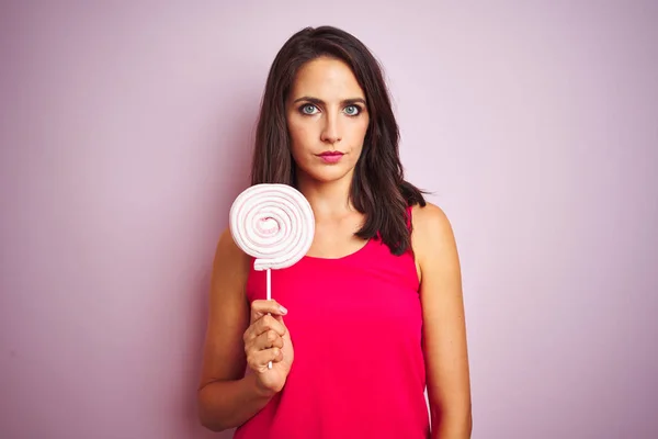 Junge Schöne Frau Essen Süße Bonbons Über Rosa Isolierten Hintergrund — Stockfoto