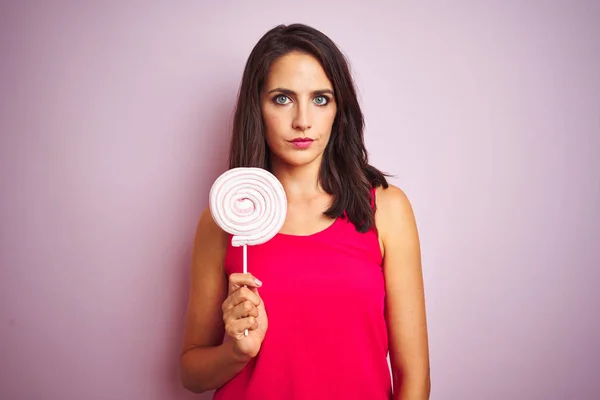 Young Beautiful Woman Eating Sweet Candy Pink Isolated Background Confident — Stock Photo, Image