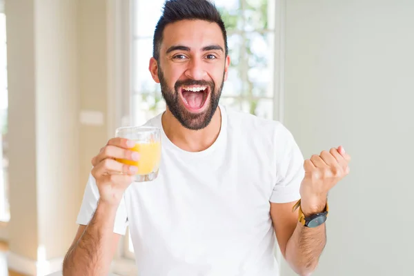 Handsome Hispanic Man Drinking Healthy Orange Juice Screaming Proud Celebrating — Stock Photo, Image