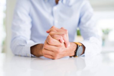 Beyaz masa üzerinde çapraz eller ile adam yakın