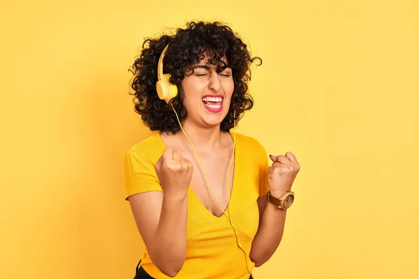 Арабская Женщина Вьющимися Волосами Слушающая Музыку Используя Наушники Изолированном Желтом — стоковое фото