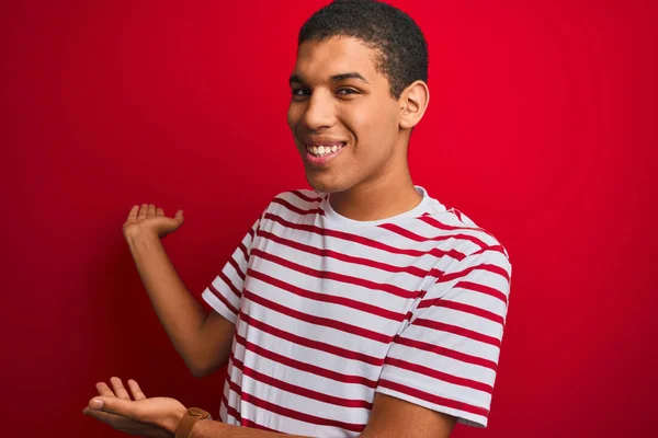 Jonge Knappe Arabische Man Draagt Gestreept Shirt Geïsoleerde Rode Achtergrond — Stockfoto