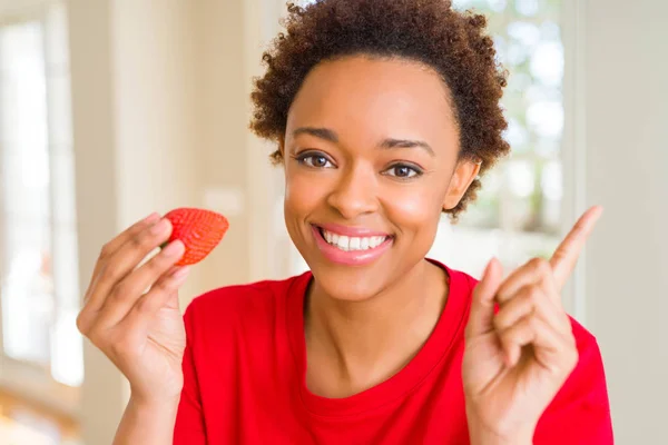 朝食に新鮮なイチゴを食べる若いアフリカ系アメリカ人女性は 手と指を横に指差してとても幸せ — ストック写真