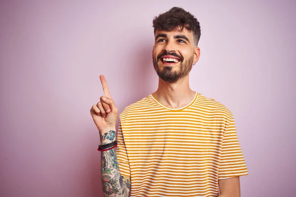 Mladý Muž Tetováním Žlutém Proužku Který Stojí Nad Osamělým Růžovým — Stock fotografie