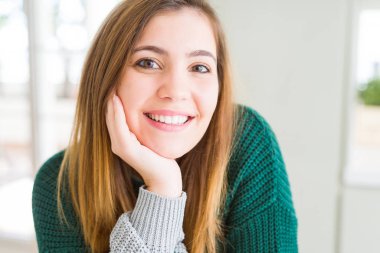 Kameraya emin gülümseyen güzel genç kadın