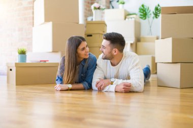 Yeni evin katında yatan genç güzel çift, gülümseyen 