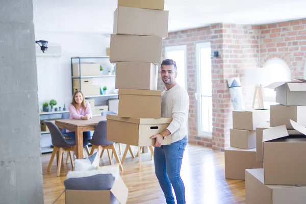 Pareja joven mudándose a una casa nueva, hombre sosteniendo cajas de cartón — Foto de Stock
