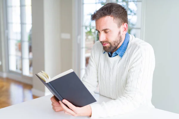 一个英俊的男人在家里看书 — 图库照片