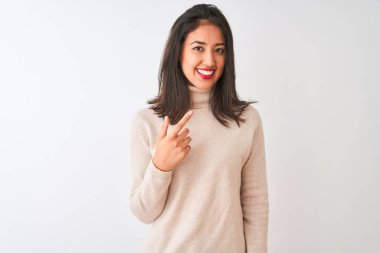 Balıkçı yaka kazak giyen güzel Çinli kadın izole edilmiş beyaz arka planda dikiliyor.