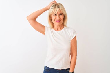 Orta yaş kadın izole beyaz arka plan üzerinde duran rahat t-shirt giyen kafa karıştırıcı ve soru hakkında merak ediyor. Şüpheyle belirsiz, eliyle kafada düşünmek. Pensive kavramı.