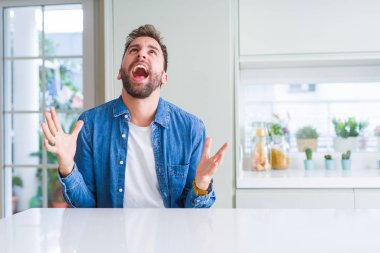 Yakışıklı adam evde deli ve deli bağırarak ve agresif ifade ve silah kaldırdı bağırıyor. Hayal kırıklığı kavramı.